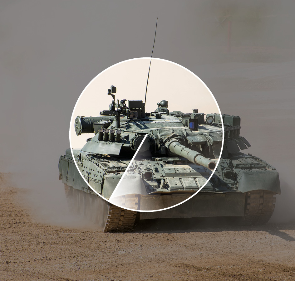 Powerful military tank rides at a high speed along the dusty field.