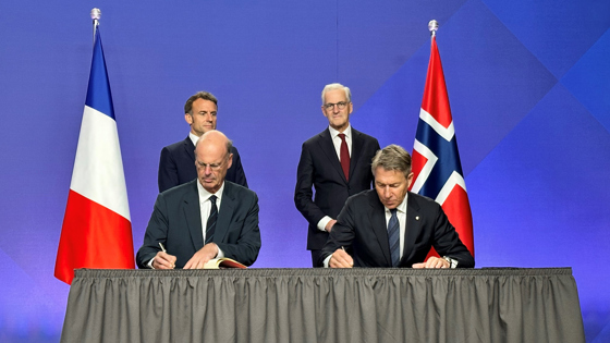Fransk økonomiminister og norsk energiminister signerer avtalen, mens president Macron og statsminister Støre står i bakgrunnen