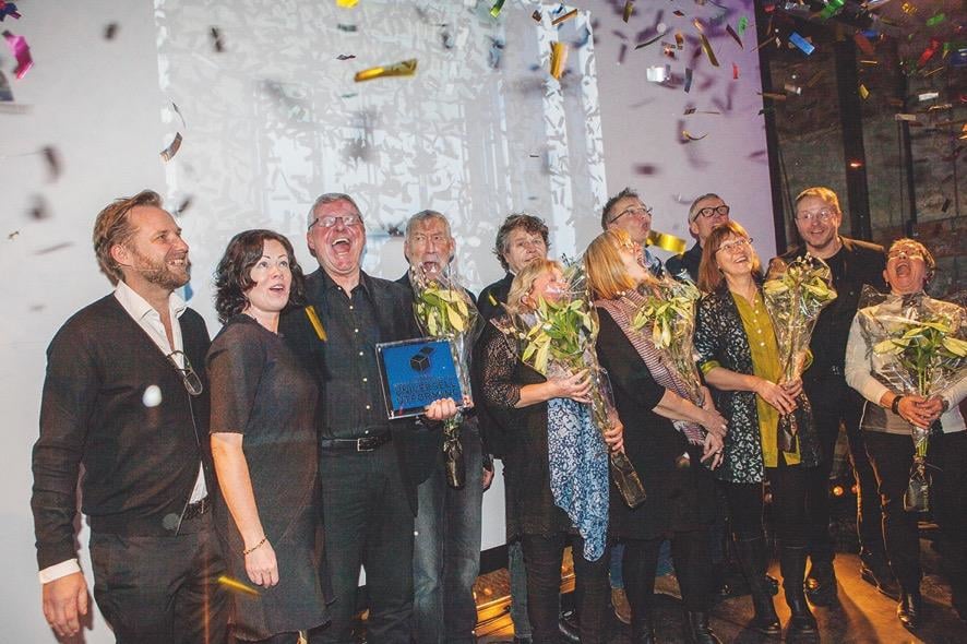 12 glade mennesker med blomster og konfetti