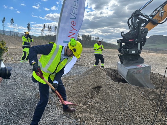 Samferdselsminister Jon-Ivar Nygård, iført verneutstyr, setter spaden i jorda på E6 forbi Lillehammer