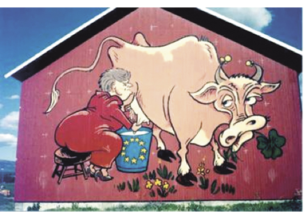 Figur 18.1 I 1994 malte en bonde på Vang i Valdres et bilde på låveveggen sin av Gro Harlem Brundtland som melket norsk landbruk for å fylle EU-bøtta. Bildet ble et kjent symbol, og solgte over 24000 t-skjorter, 2400 caps, 5000 pins, 15000 postkort og 3000 klistremerker.