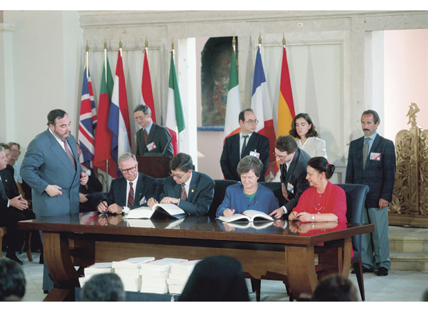 Figur 4.5 EØS-avtalen ble signert i mai 1992 i Porto, Portugal. Her ser vi fra venstre Eivinn Berg, utenriksminister Bjørn Tore Godal, statsminister Gro Harlem Brundtland og handelsminister Grete Knudsen. Foran skrivebordet ligger en stabel med alle vedleggene til EØS-avtalen.