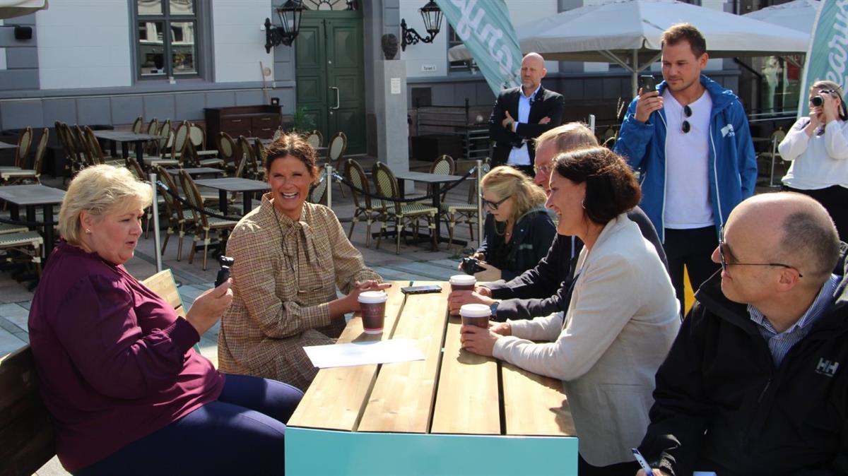 Lokale politikere og statsministeren snakker om byutvikling rundt utendørs bord.
