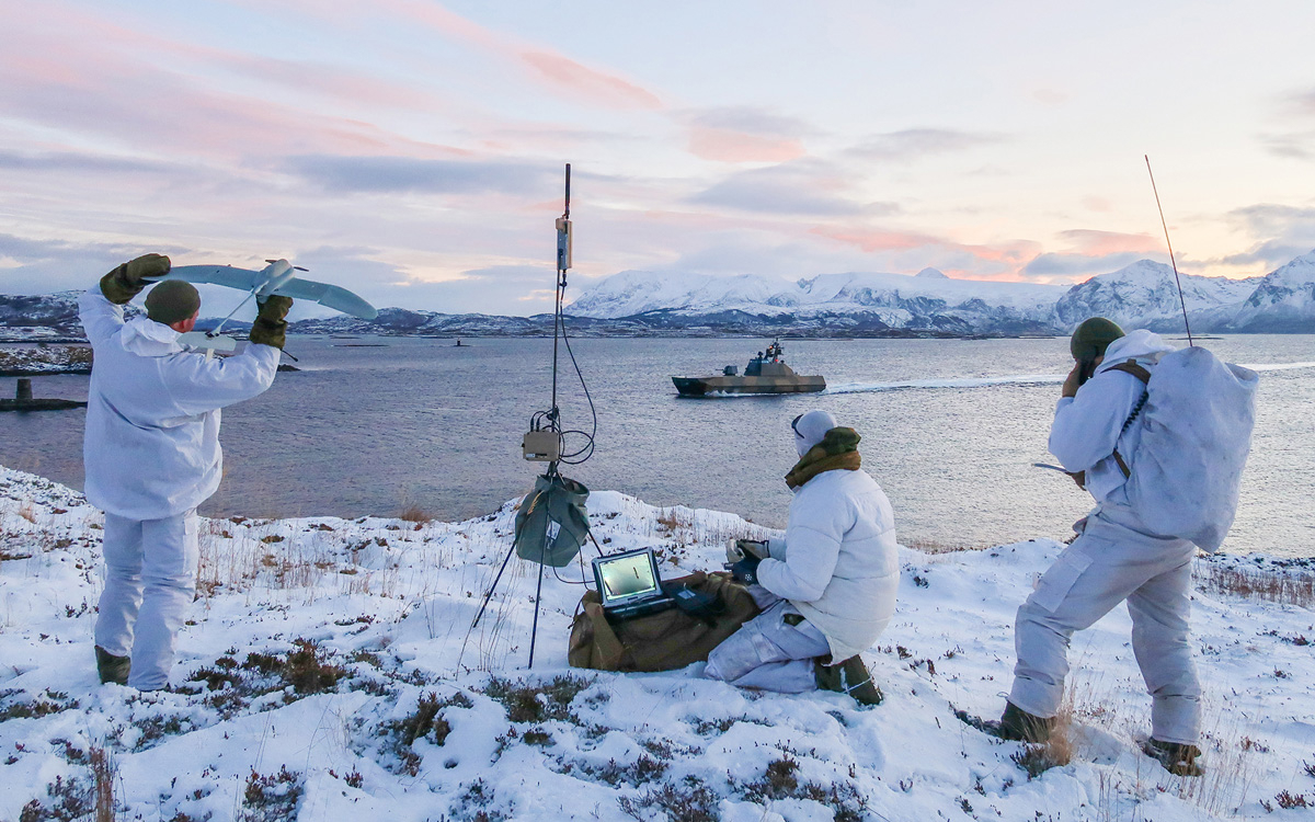 Figur 12.12 For å oppnå best mulig forsvarsevne må Forsvarets ressurser kunne samvirke. Samband og data-protokoller må derfor kunne fungere på tvers av forsvarsgrenene på lavest mulig nivå. Her øver soldater fra grensevakten sammen med en ubåt og en korvett fra ...