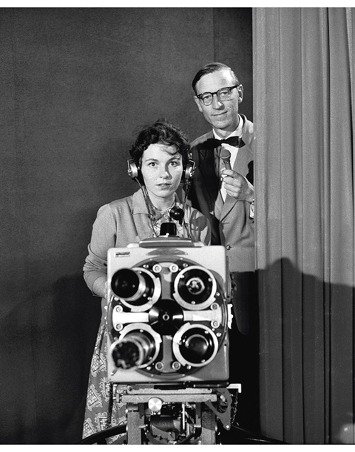Figur 2.1 NRK fjernsynet starta sine sendingar 20. august 1960 og det var kong Olav som stod for den offisielle opninga. Etter opninga hadde fjernsynet ein rask ekspansjon i tilbodet. På biletet visast redaksjonssekretær Anders Buraas saman med assistent Eva J...
