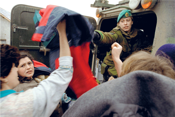 Figur 4.6 En soldat fra TMBN deler ut klær til kosovoalbanske familier i en landsby i Kosovo.
