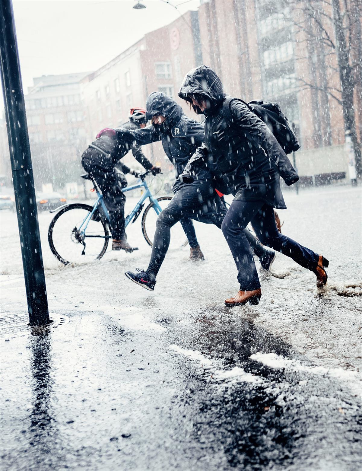 Personer i pøsregn. Foto: Ilja Hendel