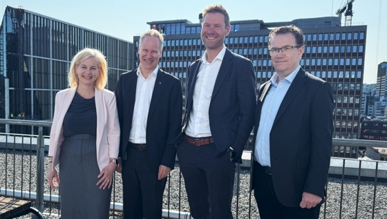 Forsknings- og høyere utdanningsminister Sigrun Aasland, samferdselsminister Jon-Ivar Nygård, Lars Andresen i NGI og John Vigrestad i Forskningsrådet smilende, utendørs med regjeringskvartalet i bakgrunnen.